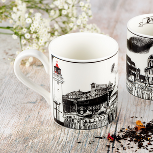 Two white ceramic mugs featuring a black and white illustrations of various famous landmarks in Brightron