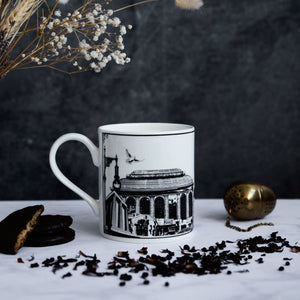 White ceramic mug designed by powder butterfly featuring a black and white illustration of Edinburgh city's famous landmarks