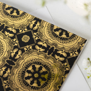 Black soft-touch greeting card with Newcastle landmarks-themed gold mandala patterns on a white surface.