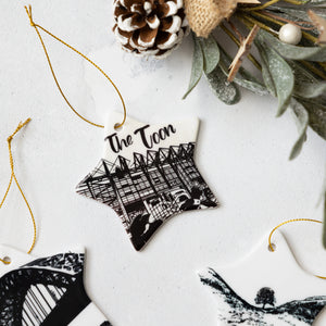 Star-shaped ornament with 'The Toon' text and St James' Park silhouette, with two magpies surrounded by decorative elements on a light background.