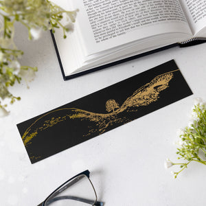 Northumberland-themed gift: Black and gold foil bookmark featuring the Sycamore Gap Tree on a white surface with an open book and glasses.