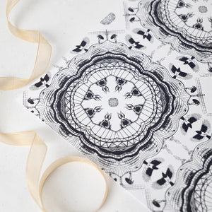 Black Newcastle-themed mandala design on a white background with a beige ribbon