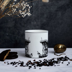 Front facing side of the Dunston Staiths mug featuring various hand draws wildlife and the staiths themselves.