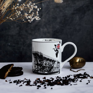opposite side of the dunston staiths mug featuring a "made in engalnd" sticker, wildlife and the hand drawn design of the staiths.