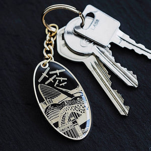 PowderButterfly Newcastle Landmarks Keyring with black and gold trim illustrations of Newcastle and Gateshead monuments and landmarks