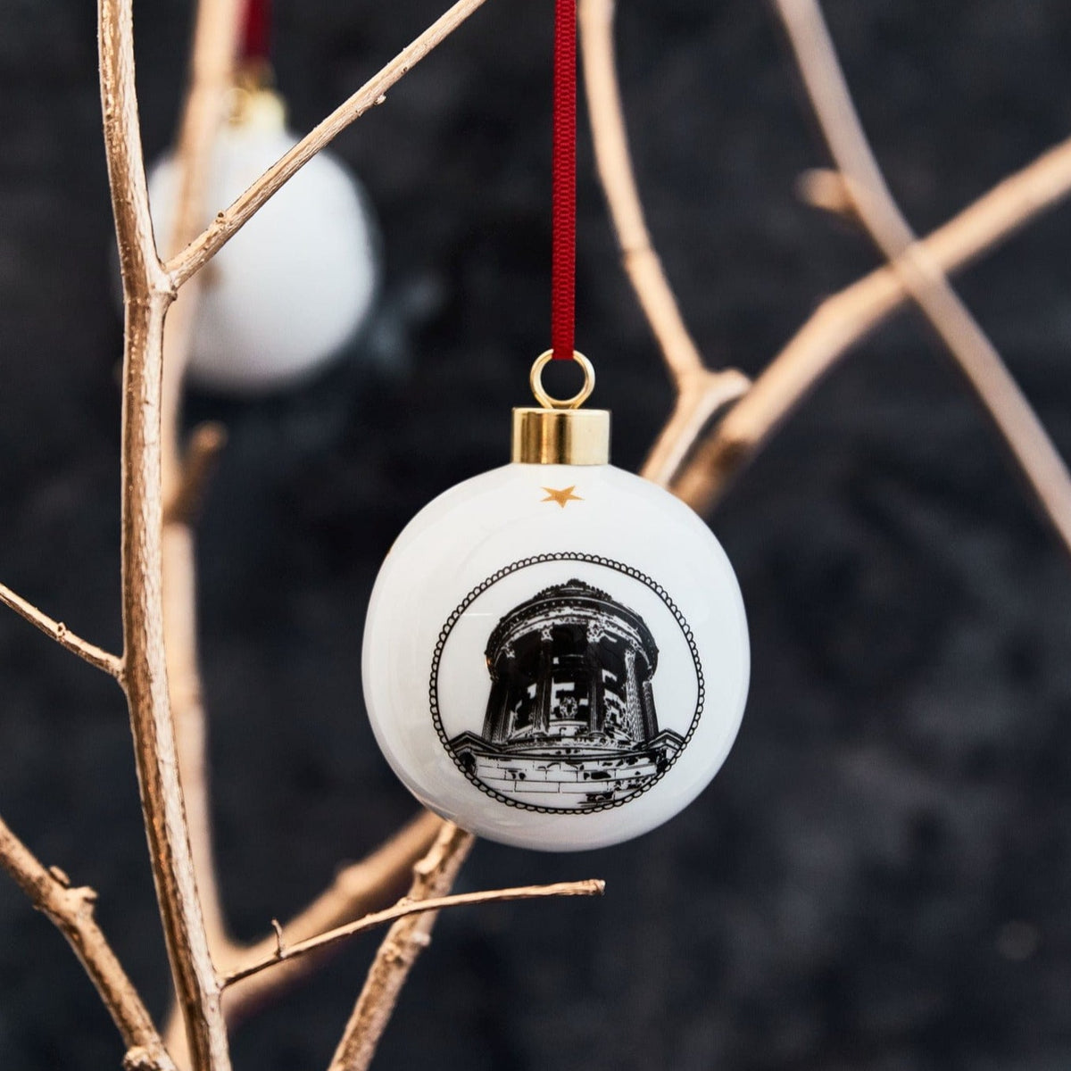 white ceramic bauble featuring a black and white illustration of Burns Monument complete with gold trim and red ribbon by powder butterfly