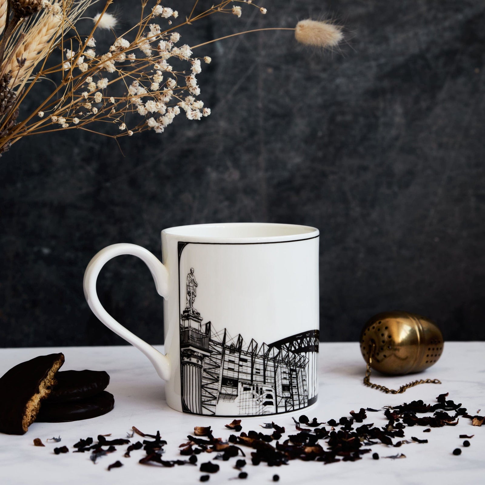 white ceramic mug featuring a black and white illustration of st. james' park and various other Newcastle and Gateshead landmarks and symbols