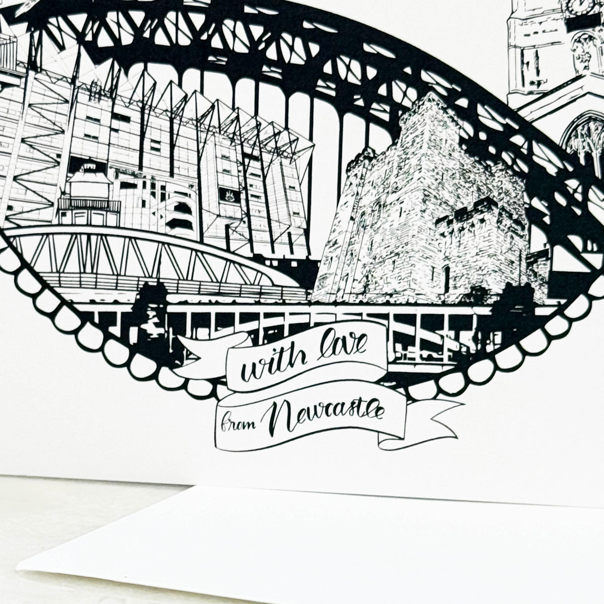 Black and white illustration of a bridge with text 'With love from Newcastle' on a white background