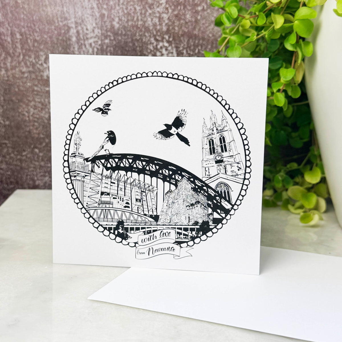 Greeting card with black and white illustration of a bridge and buildings on a white background