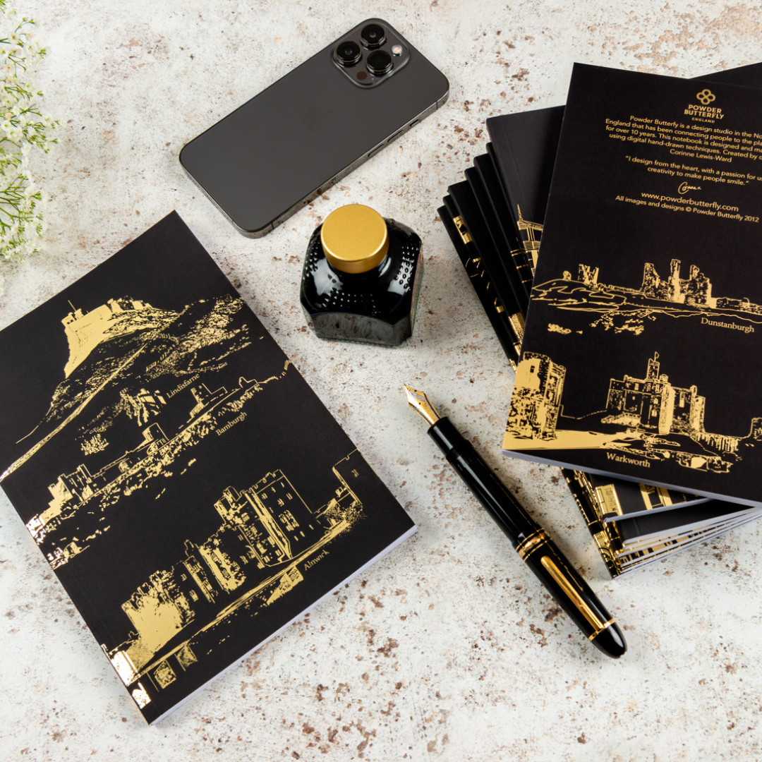 Black notebook with gold foil illustrations of famous Northumberland castles in the UK