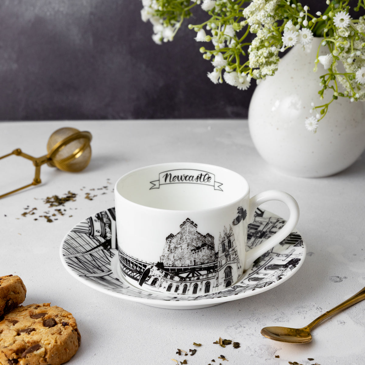 Newcastle themed teacup and sauced set, image contains various tea accessories.