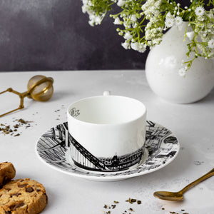Side image of the Newcastle tea cup and saucer set by powder Butterfly featuring a black and white print of Newcastle landmarks.