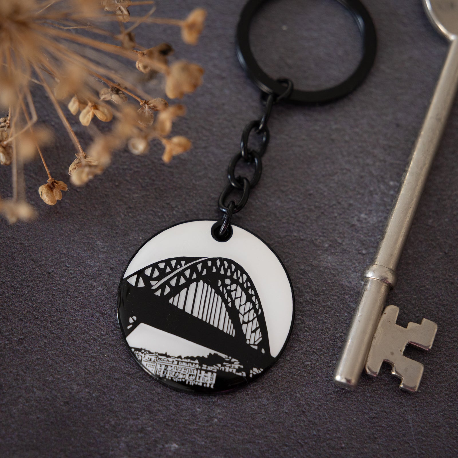 Black and white illustrated enamel keyring featuring the tyne bridge by powder butterfly