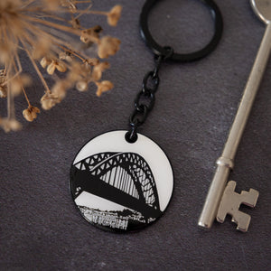 Black and white illustrated enamel keyring featuring the tyne bridge by powder butterfly