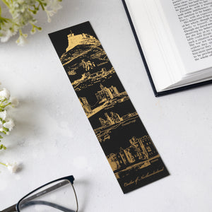 Black soft touch bookmark with gold foil castle design on a white background with an open book in the corner. 