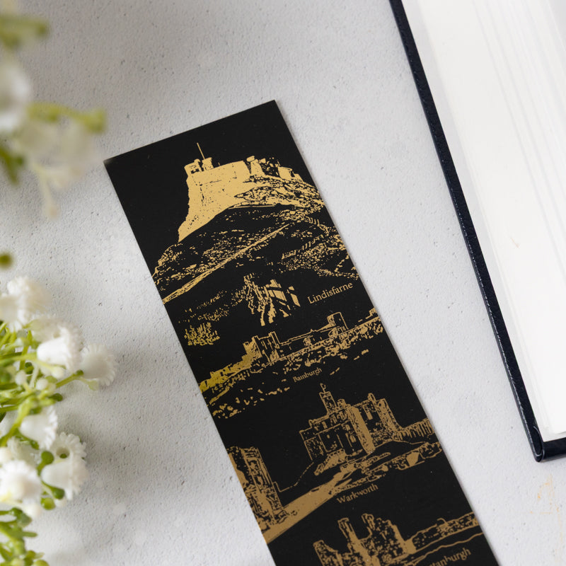 Details of Black soft touch bookmark with gold foil castle design on a white background.