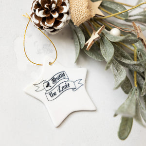 Decorative star ornament with text Howay The Lads and pine cone on a light background