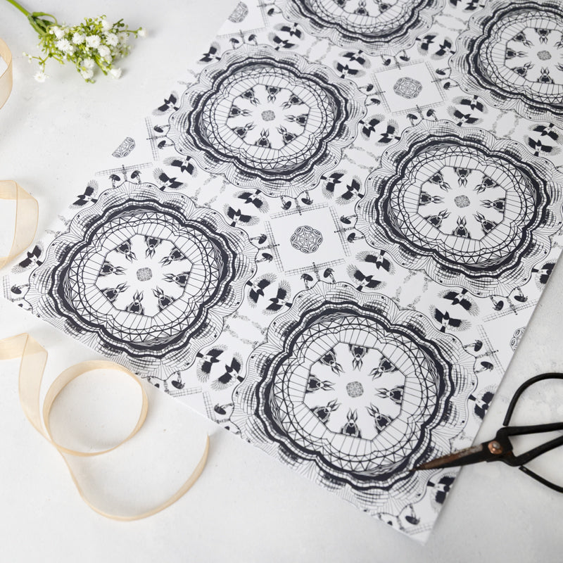 Black and white patterned paper with scissors and ribbon on a light background