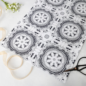 Black and white patterned paper with scissors and ribbon on a light background