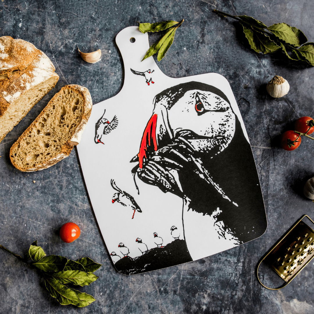 Farne Island Puffin Chopping Board - Powder Butterfly featuring a black adn white illustrated design of some puffins detailed with orange